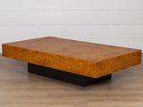 une table basse en bois avec un piètement noir posée sur un parquet