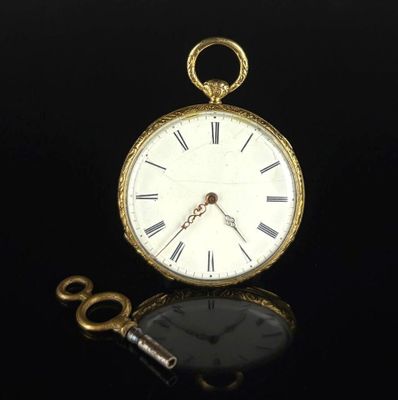 a gold pocket watch and a key on a black surface