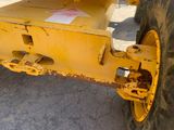 a close up of a large yellow truck with a big tire