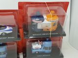 four toy cars in a display case on a white surface