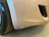 a close up of a car ' s front bumper with a denting on it