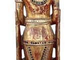 wooden statue of a person with a hat on top of it