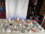 de nombreuses figurines posées sur une table devant un fond blanc