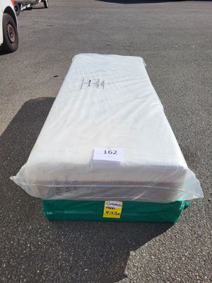 un matelas posé au milieu d'un parking
