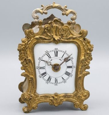 une horloge en or avec des chiffres romains sur le cadran