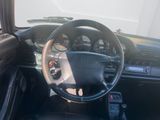 a dashboard and steering wheel of a car in a parking lot