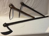une paire d'outils de jardinage anciens et rouillés posés sur une surface blanche