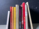 une pile de livres posée sur une table près d'un mur noir