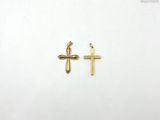 une paire de croix dorées sur fond blanc