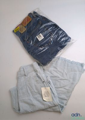 deux paires de jeans bleus posées sur une table blanche