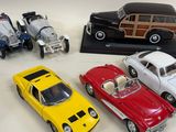 several toy cars are lined up in a row on a white surface