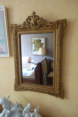 un miroir accroché au mur à côté d'un vase