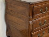an image of a wooden chest of drawers sitting on top of a carpeted floor