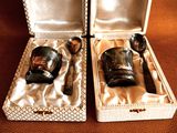 two silver spoons and a glass in a box