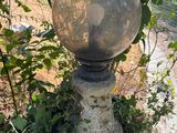 une boule de pierre posée sur un socle en pierre