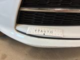 a close up of a white car with a sticker on the front of it