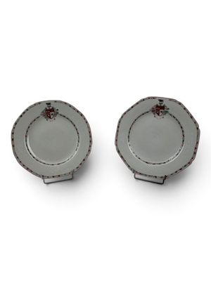 pair of small plates with red flowers on them sitting on a white surface