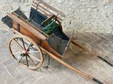 une petite charrette en bois avec un sac vert à l'intérieur