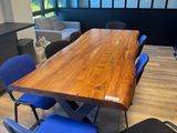 a wooden table and blue chairs in an office setting