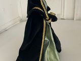 figurine of a man dressed in black and green with a crown on his head