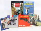 several books on a white surface with a gun and a gun