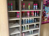 a display case with several bottles of soda in it