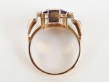 a close up of a gold ring with purple stones on it