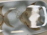 a plate with a fish design on it on a table