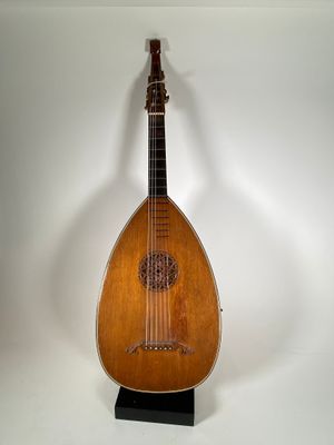 un petit instrument en bois posé sur un support, sur une surface blanche