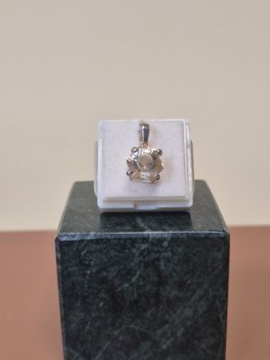 bague plaquée argent ornée d'une fleur posée sur un bloc de marbre noir