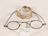 a pair of glasses and a bracelet sitting on a table