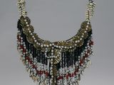 a close up of a necklace on a stand on a white background