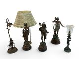 three bronze figurines and a lamp shade on a white background