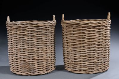 pair of wicker baskets with handles on a grey background