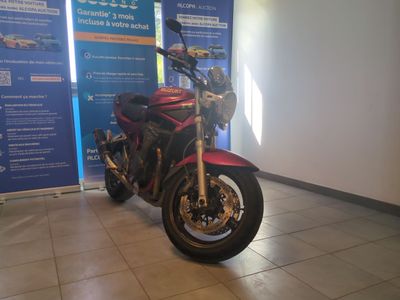 une moto rouge garée devant un mur bleu