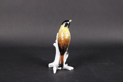 une figurine représentant un oiseau perché sur une branche
