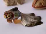 a fish figurine sitting on a table next to other figurines