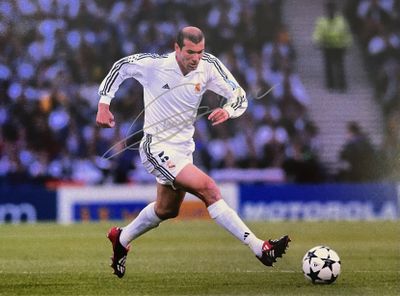 un homme qui tape dans un ballon de foot sur le terrain