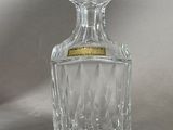 clear glass decanter with a gold label on the top of it