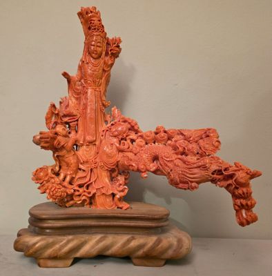 Figurine chinoise sculptée représentant une femme et un dragon, posée sur un socle en bois