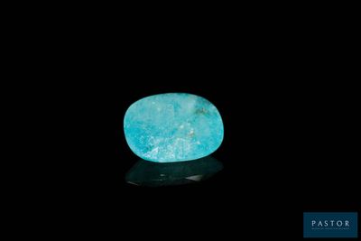 a blue stone on a black surface with a black background