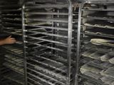 a man that is standing in front of some trays of food