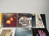 several cds and cds on a table with a person ' s hand in the background