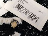 two tags on a black and white sweater with a picture of a bear