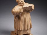 une statue représentant un homme tenant un livre dans ses mains