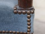 a close up of a wooden chair with a blue upholstered seat