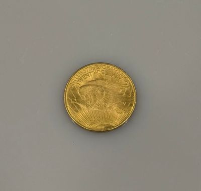 gros plan d'une pièce d'or sur une surface blanche