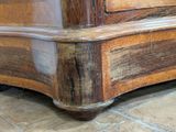 a close up of a wooden dresser on a tile floor