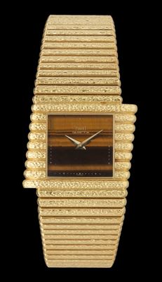 un gros plan d'une montre-bracelet dorée sur fond noir