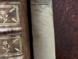 two old books sitting on a table next to each other